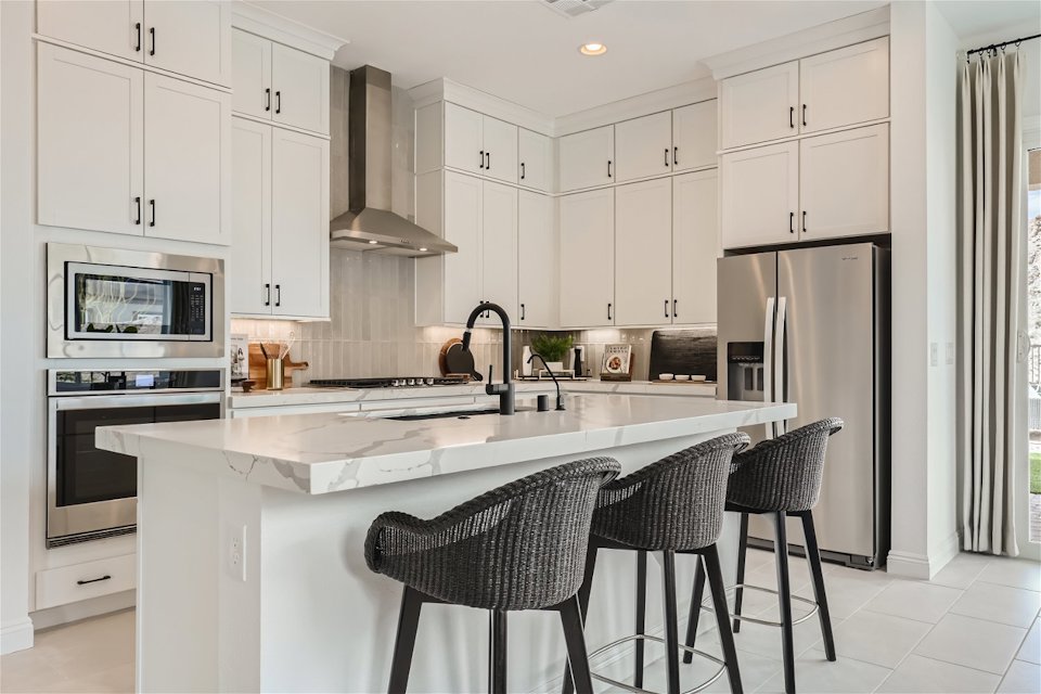A kitchen with white cabinets.