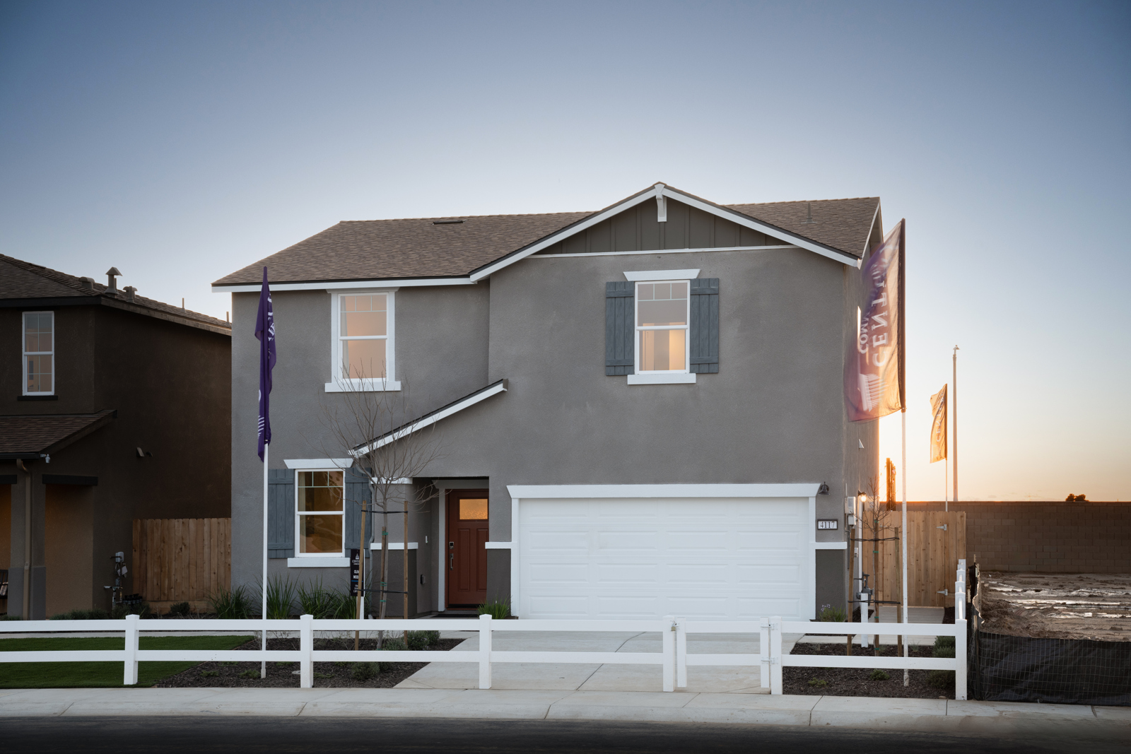 A house with a garage and a white fence.