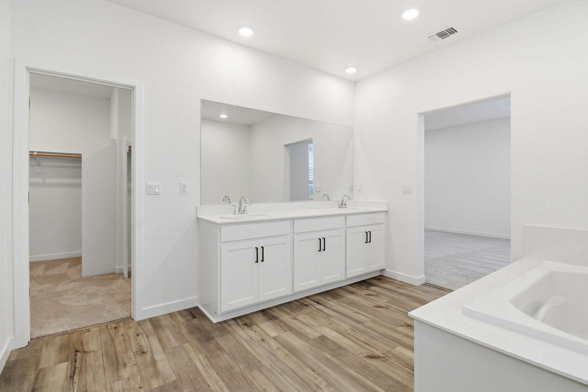 A bathroom with white cabinets.