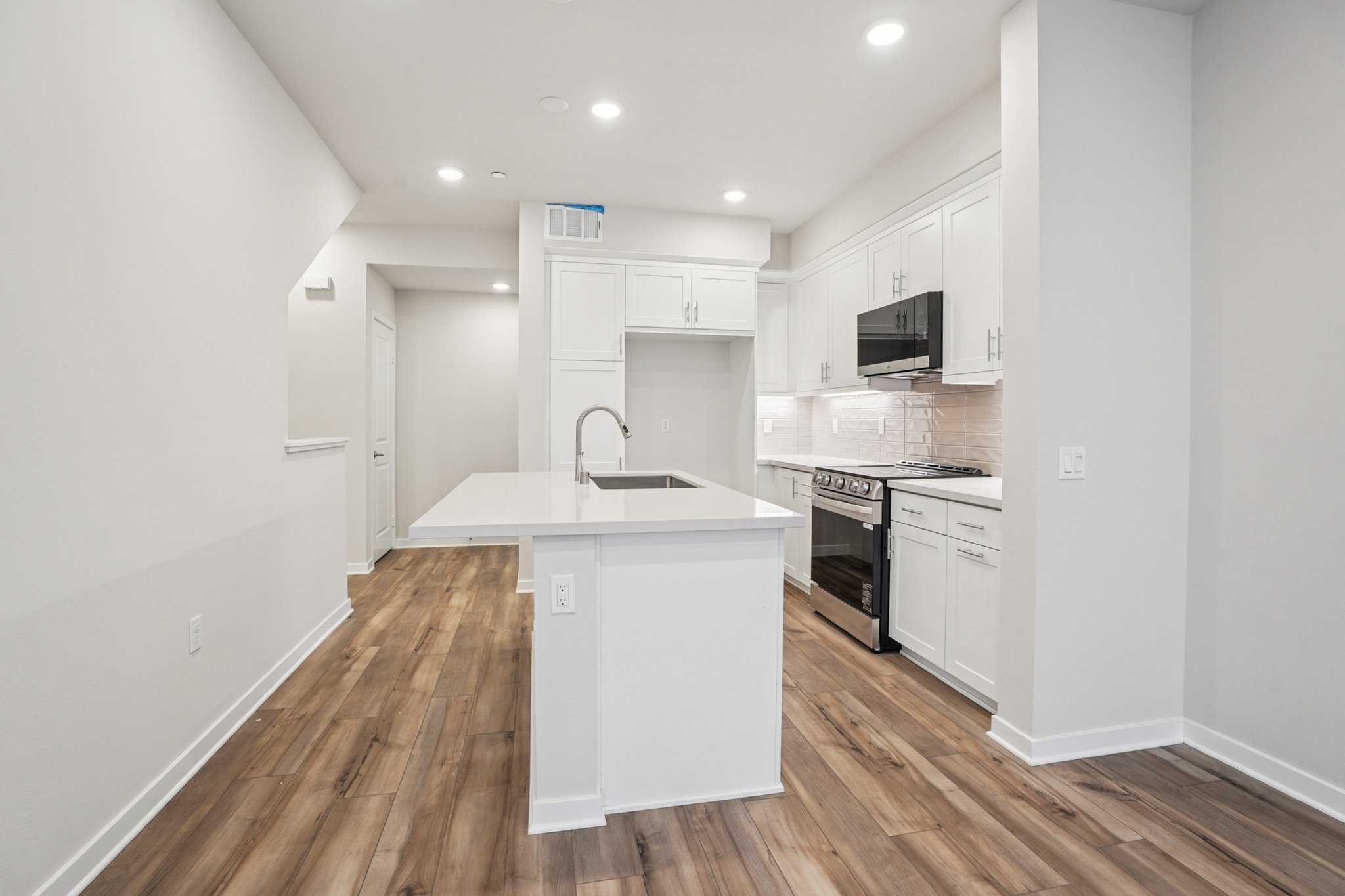A kitchen with white cabinets.