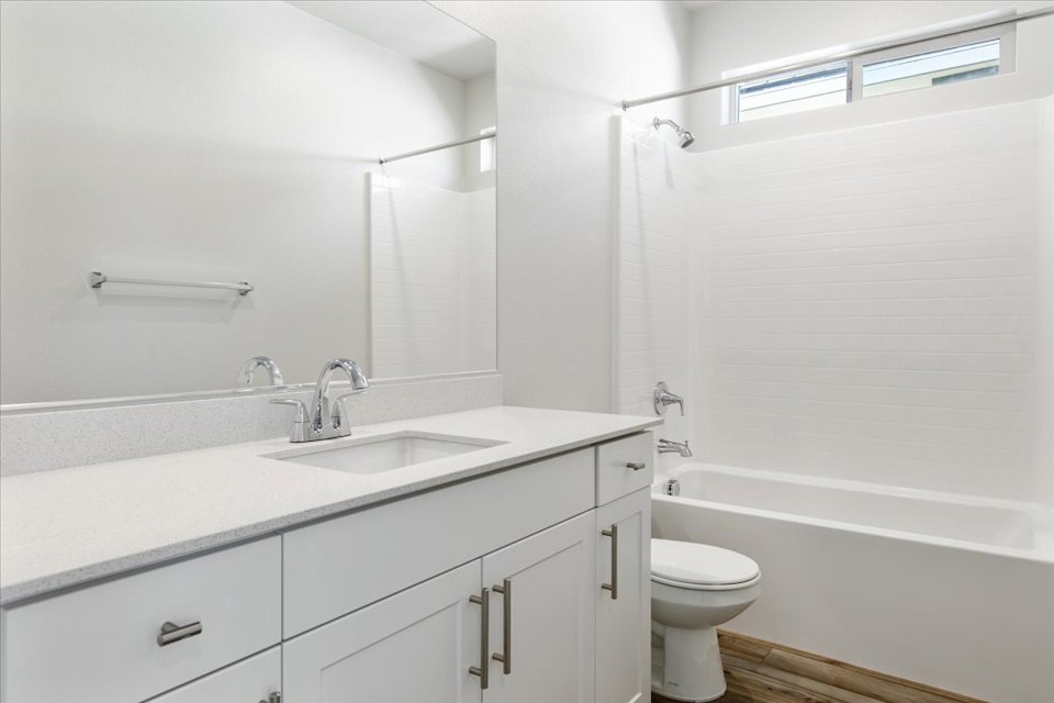 A bathroom with a sink toilet and bathtub.