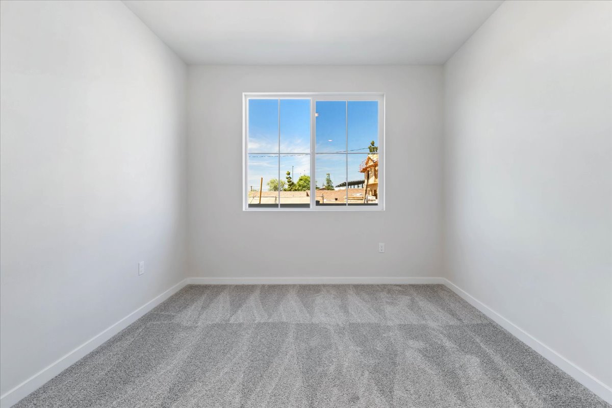 A room with a window and a painting on the wall.