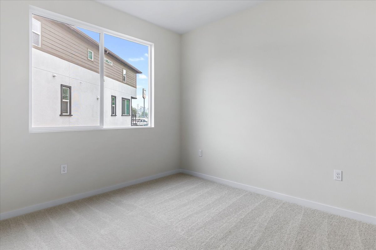 A room with a window and a white wall.