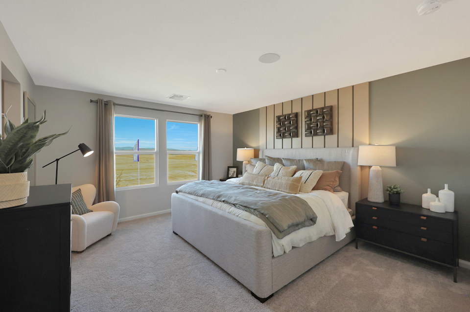 A bedroom with a bed and a chair.