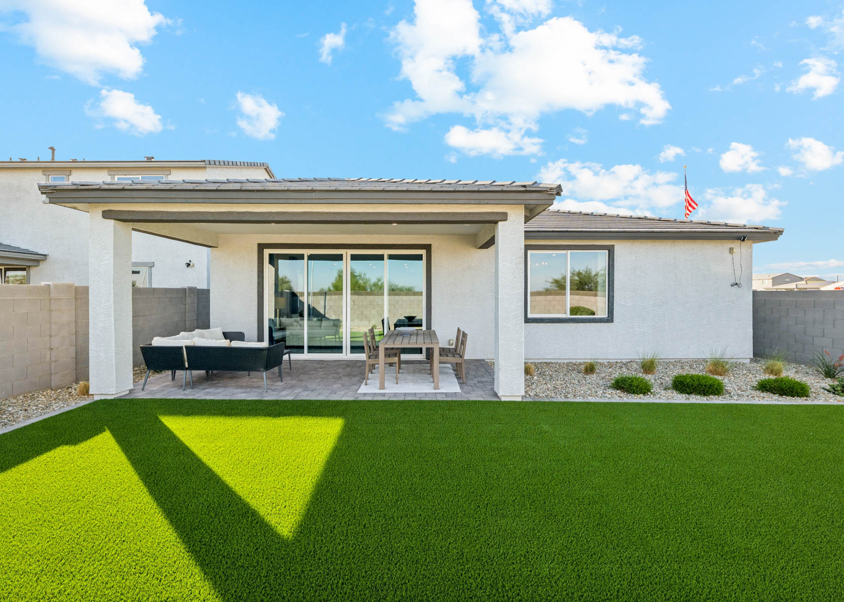 A house with a lawn and a table and chairs in the front.