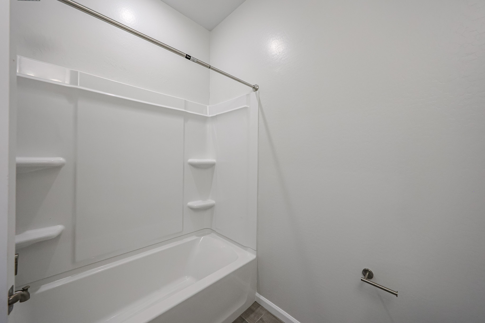 A bathroom with a shower unit and toilet.