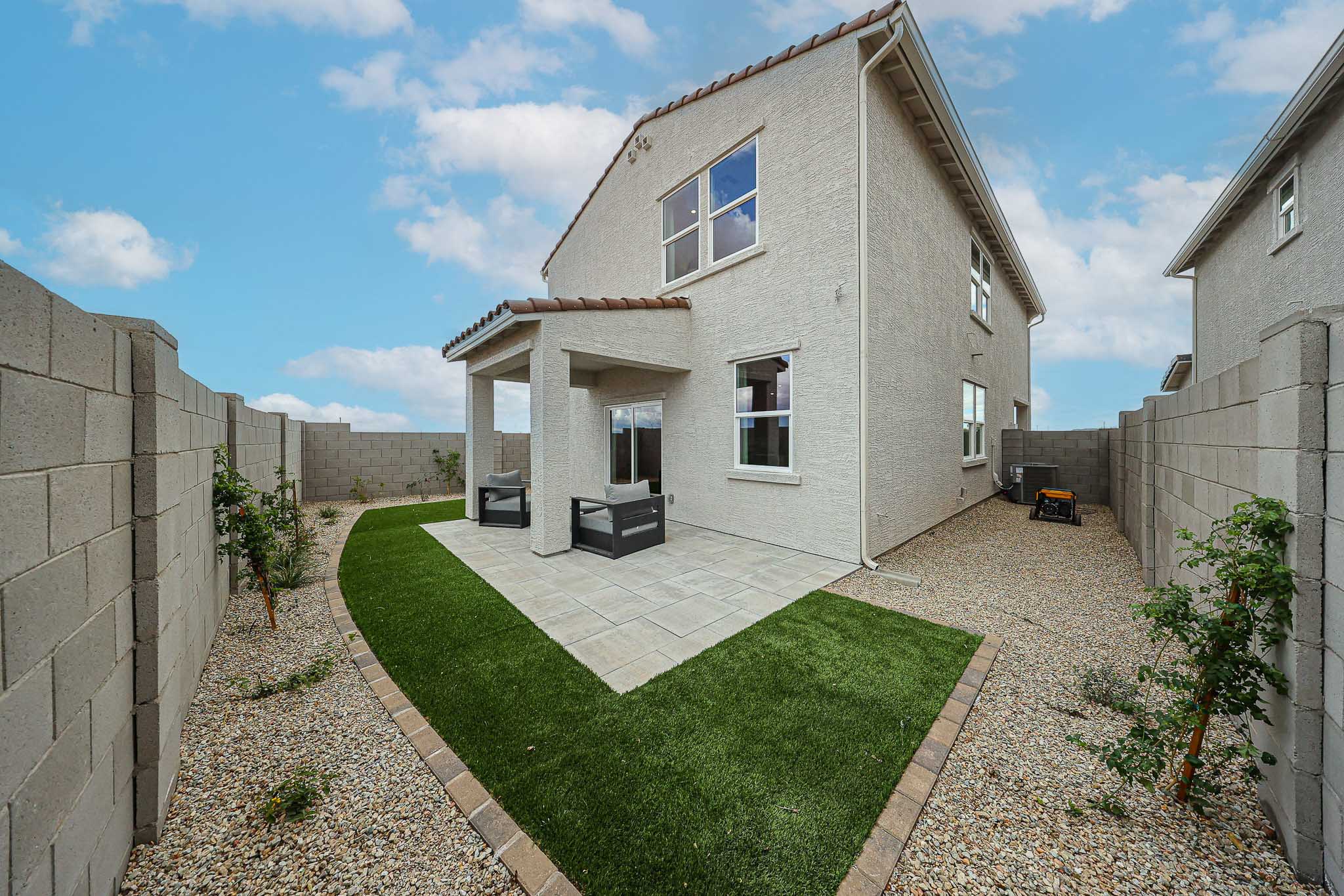 A stone building with a grass yard.