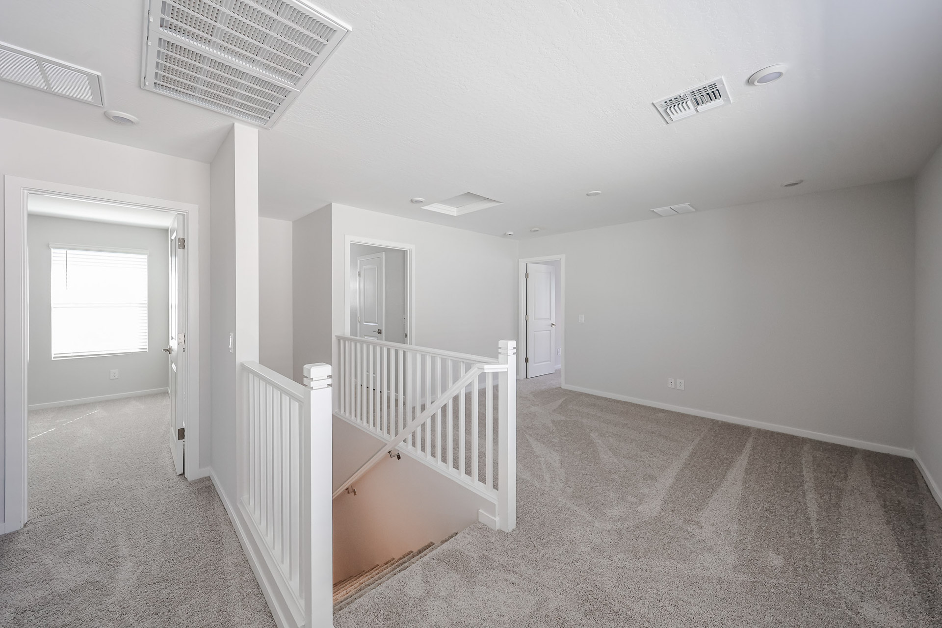 A white room with a white railing.