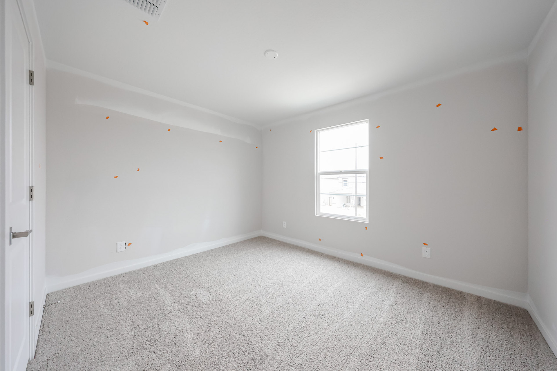 A room with a carpet and a window.