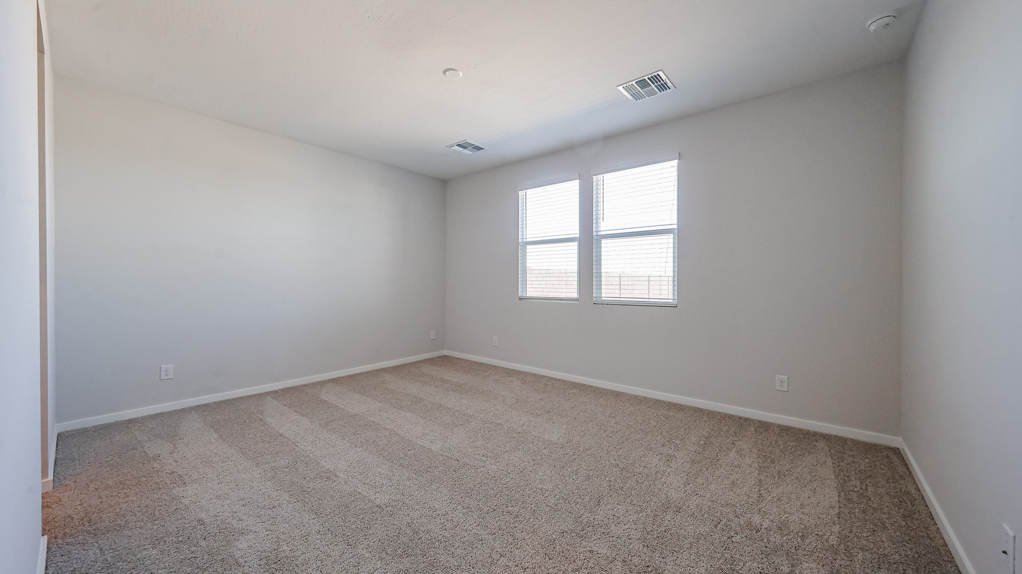 A room with a carpet and windows.
