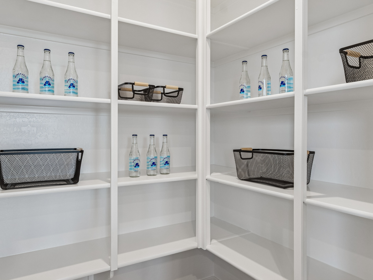 A white shelving unit with white shelves and baskets.