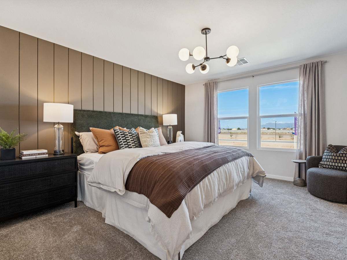 A bedroom with a bed and a chair.