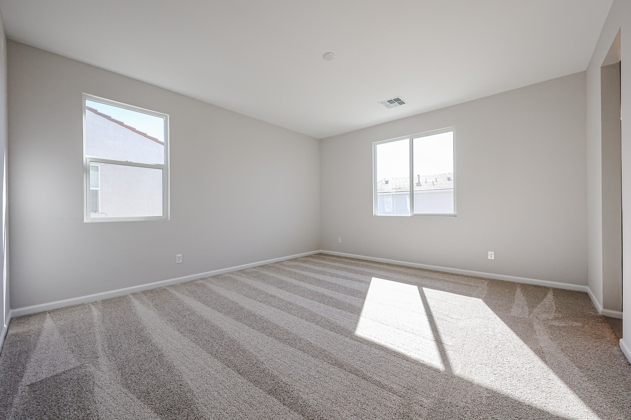 A room with a rug and windows.