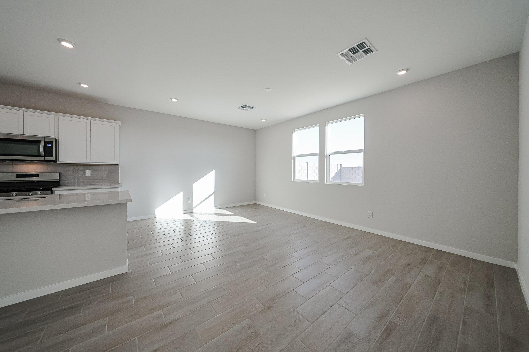 A large empty room with a wood floor and white walls.
