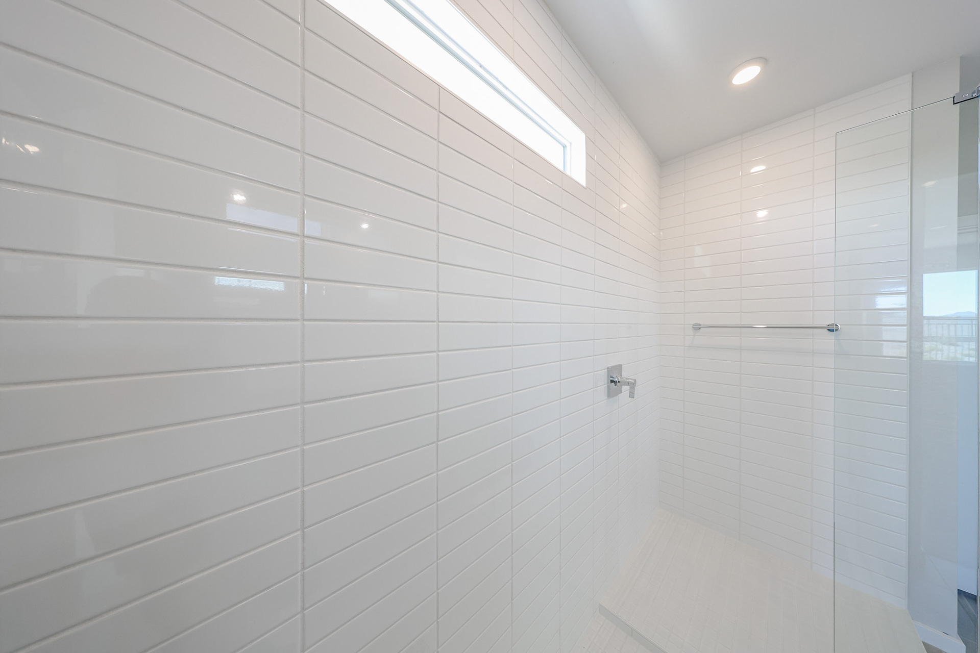 A white shower with a glass door.