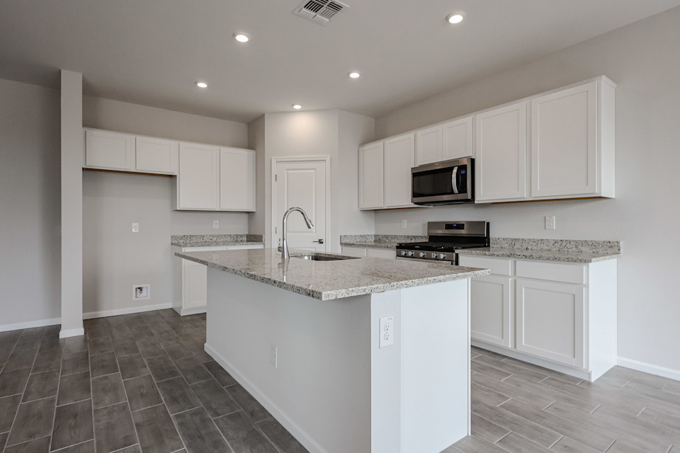 A kitchen with white cabinets.