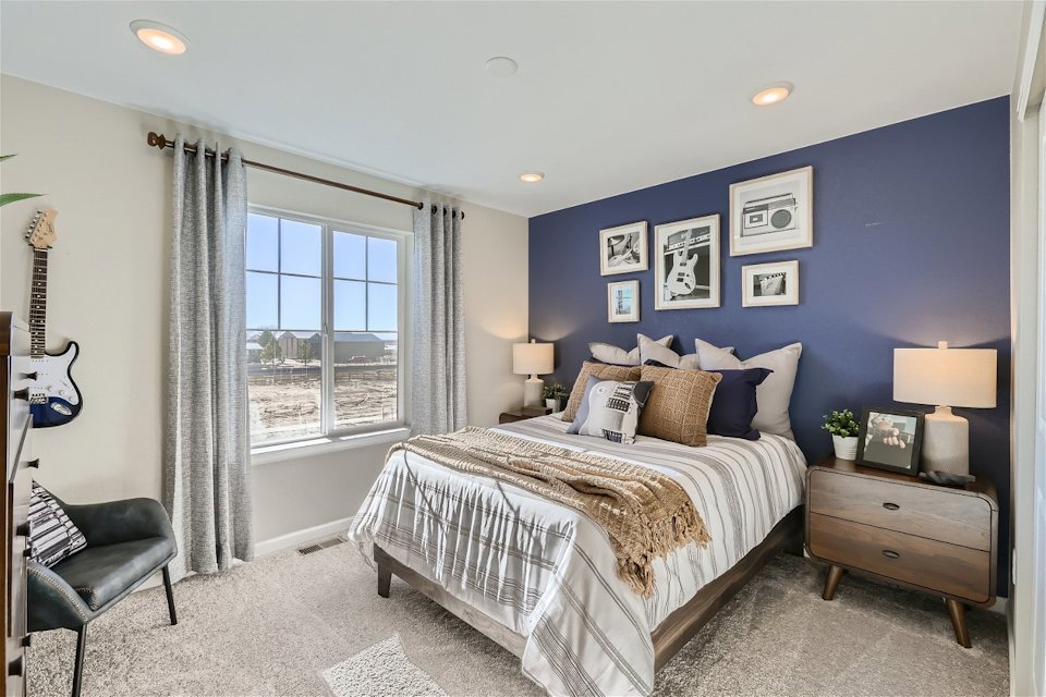 A bedroom with a bed and a chair.