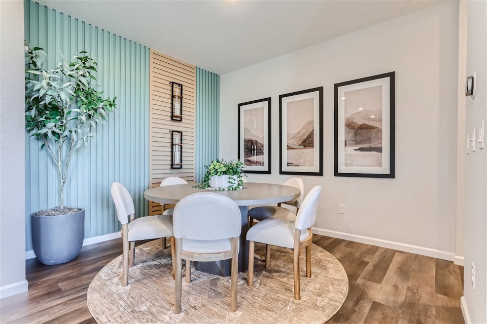 A dining room with a table and chairs.