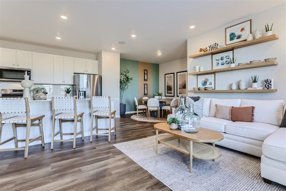 A large living room with a wood floor and white couches.