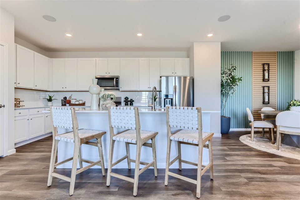 A kitchen with a dining table and chairs.