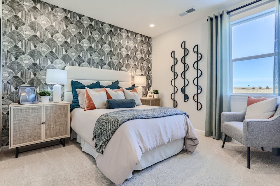 A bedroom with a bed and a chair.