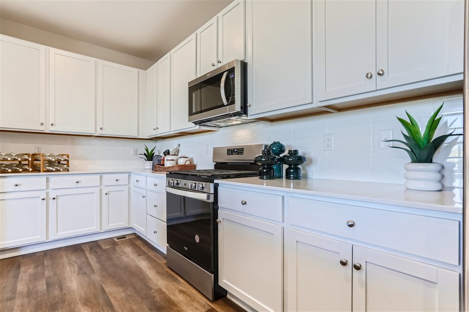 A kitchen with white cabinets.