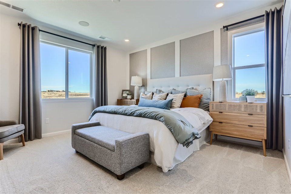 A bedroom with a bed and a chair.