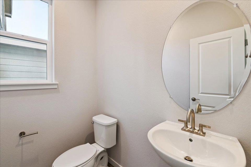 A bathroom with a round mirror.