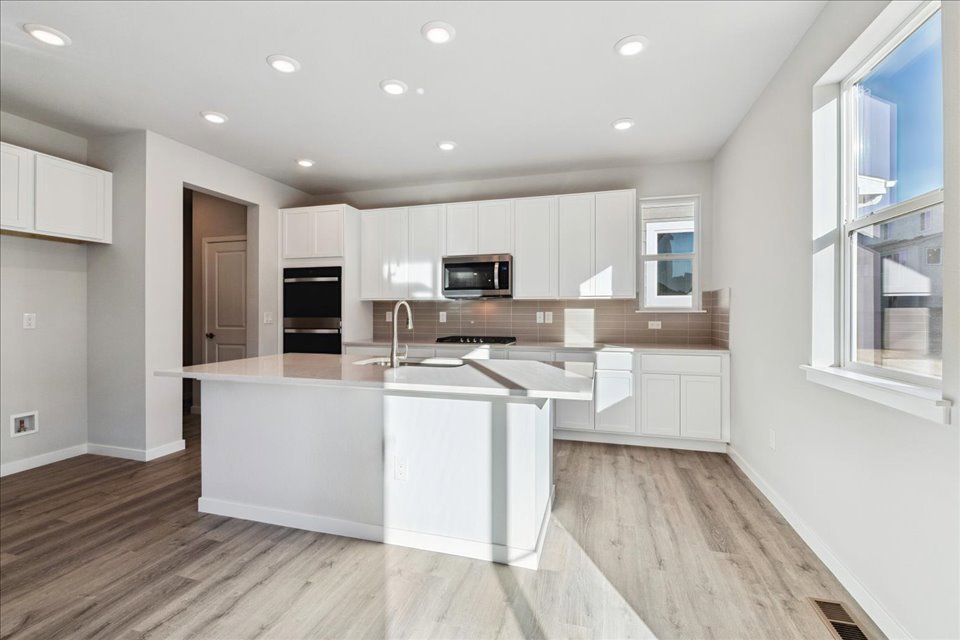 A kitchen with white cabinets.