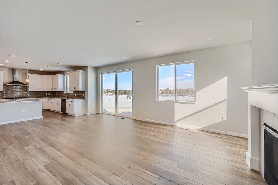 A large kitchen with a wood floor.