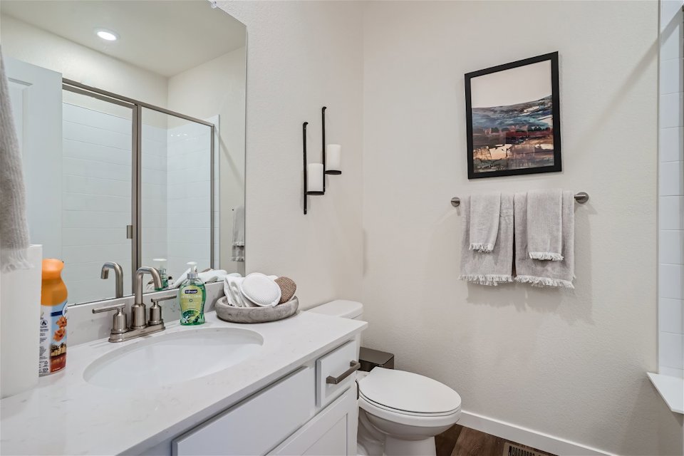 A bathroom with a sink toilet and towels.