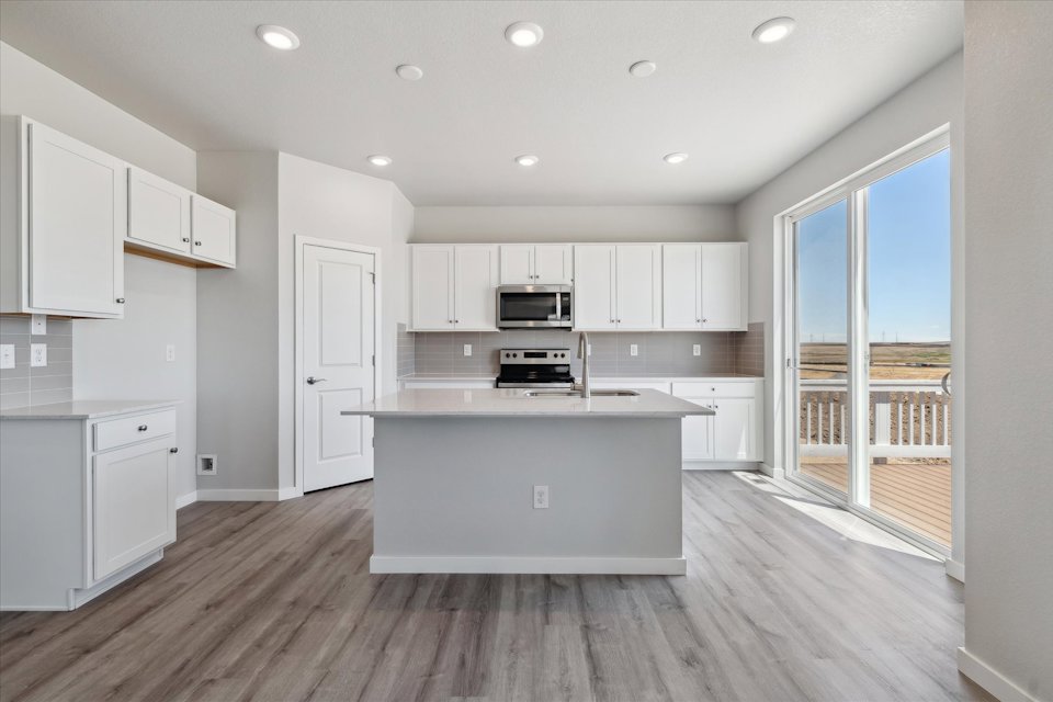 A kitchen with white cabinets.