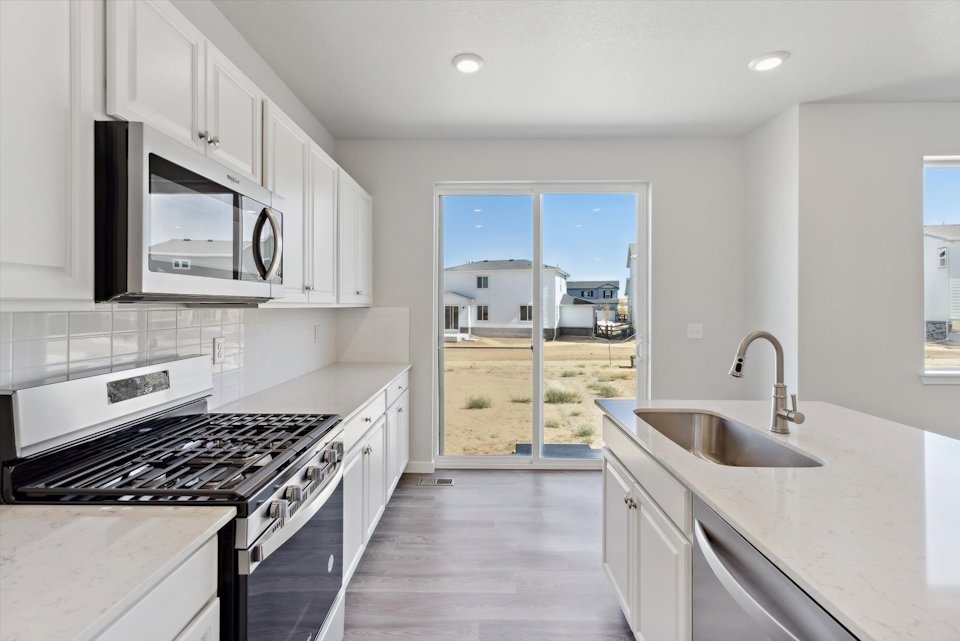 A kitchen with white cabinets.