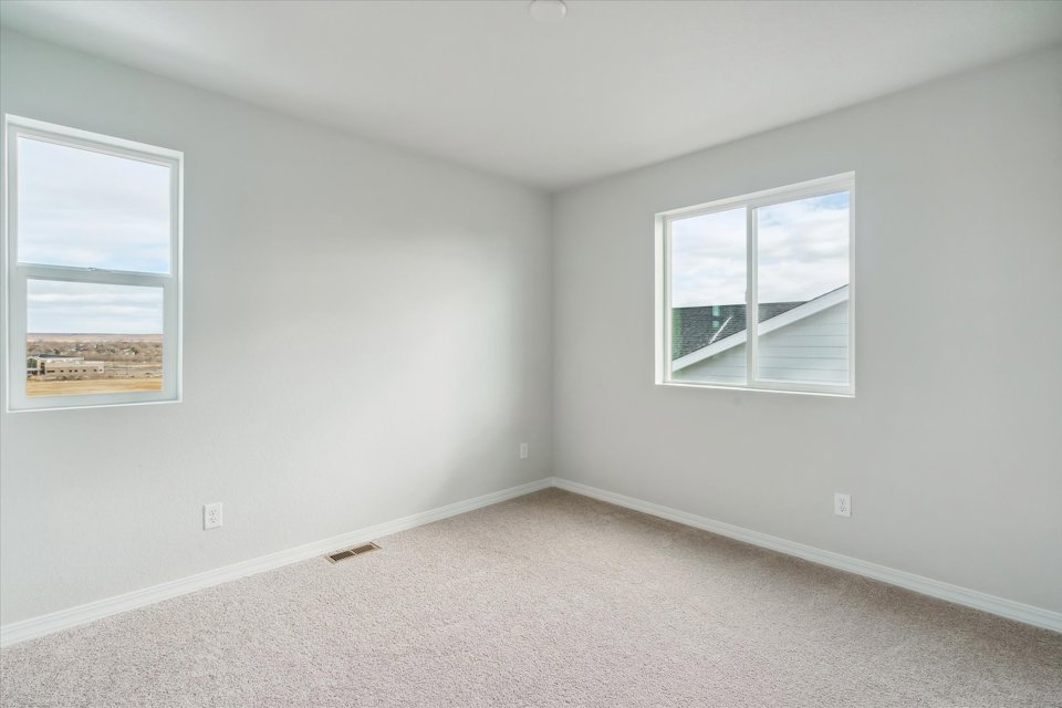 A room with a window and a painting on the wall.
