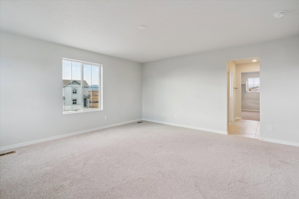 A room with a carpet and a window.