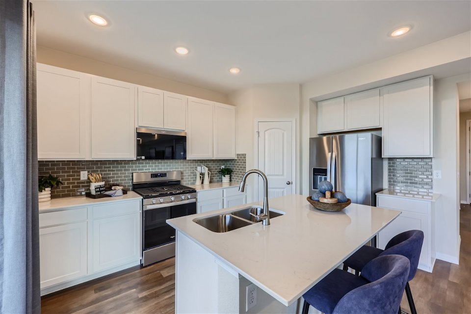 A kitchen with white cabinets.
