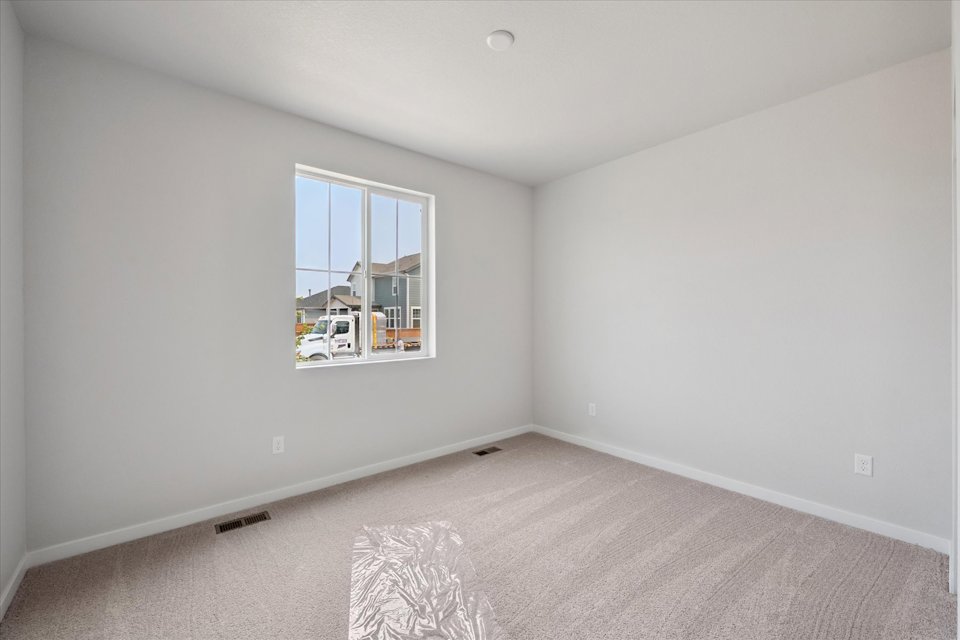 A room with a window and a rug.