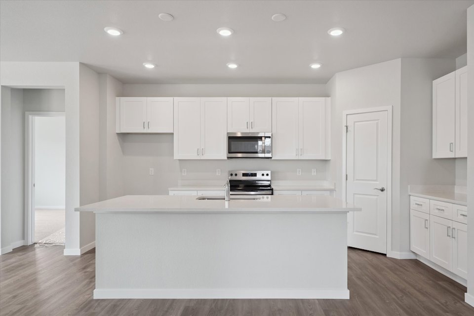 A kitchen with white cabinets.