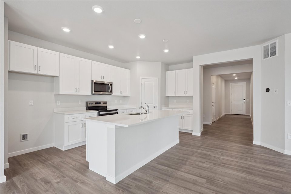 A kitchen with white cabinets.