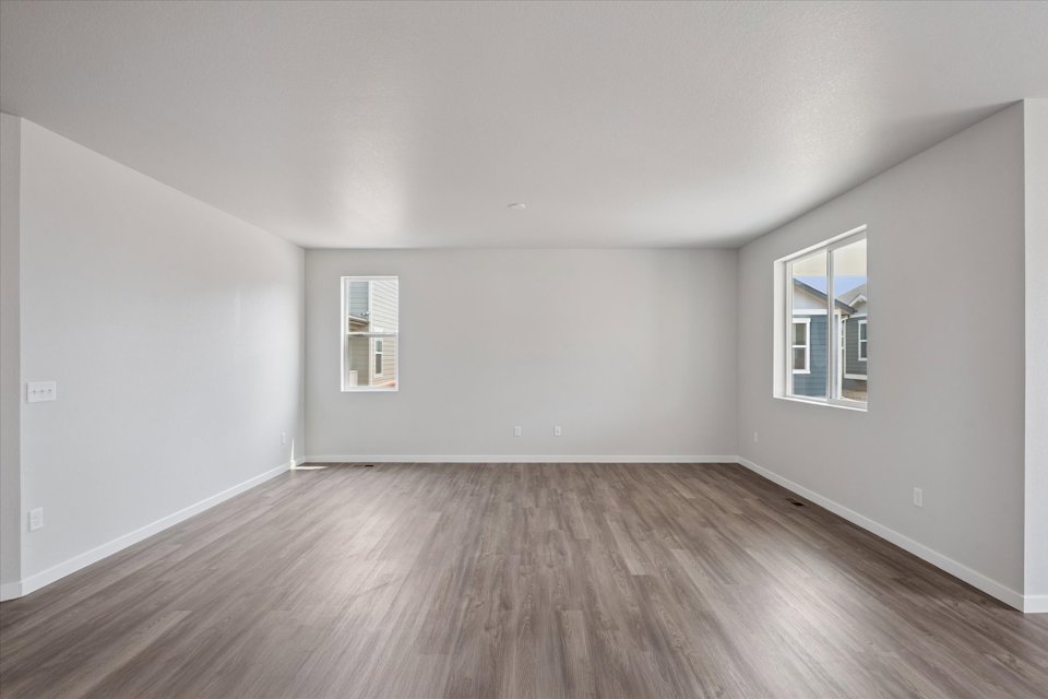 A room with a wood floor and windows.