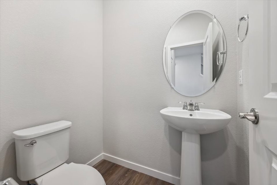 A bathroom with a round mirror.