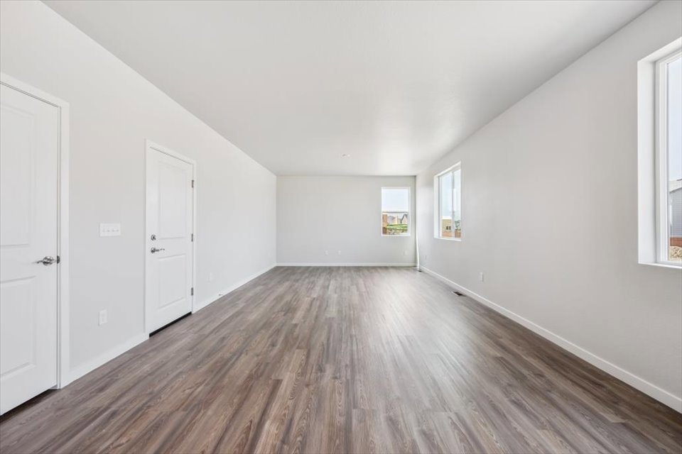 A room with white walls and wood floors.