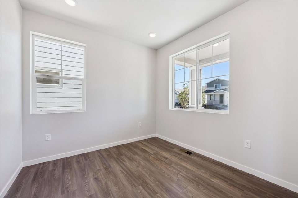 A room with a window and a wood floor.