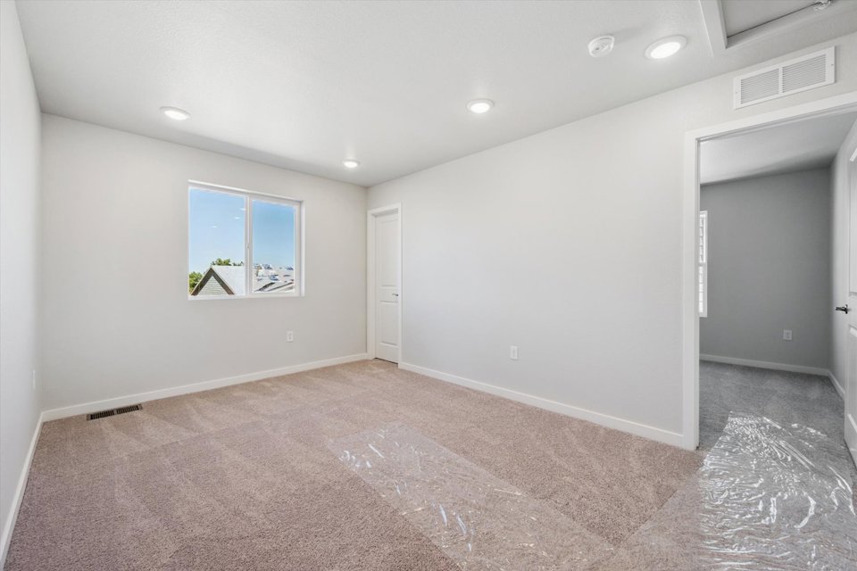 A room with a carpet and a window.