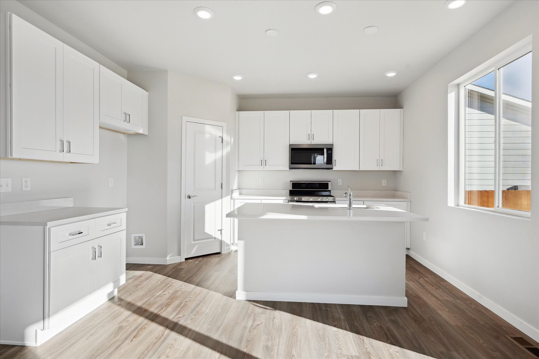 A kitchen with white cabinets.