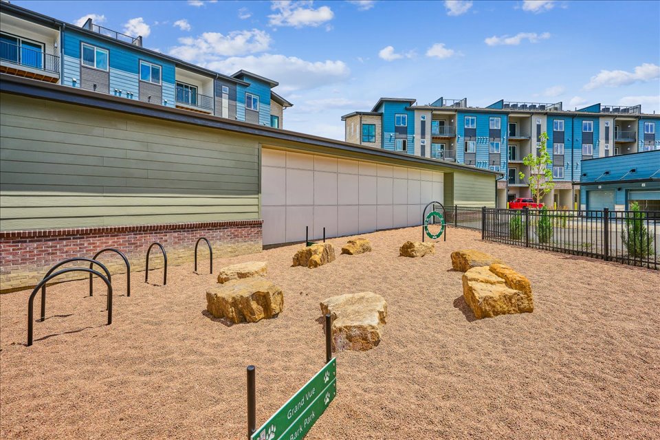 A sandy beach with buildings in the background.
