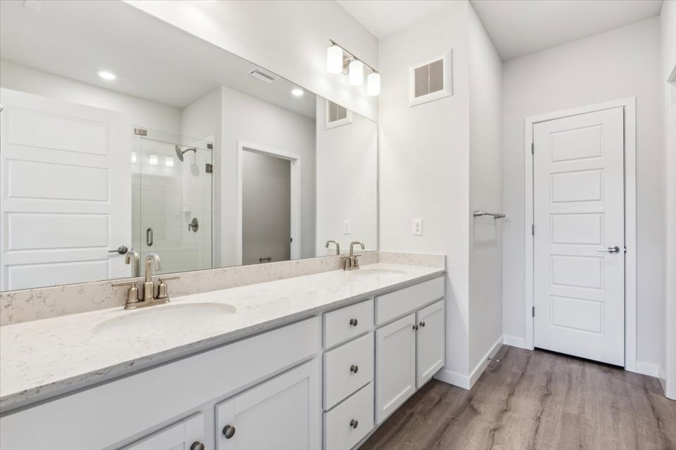 A bathroom with white cabinets.