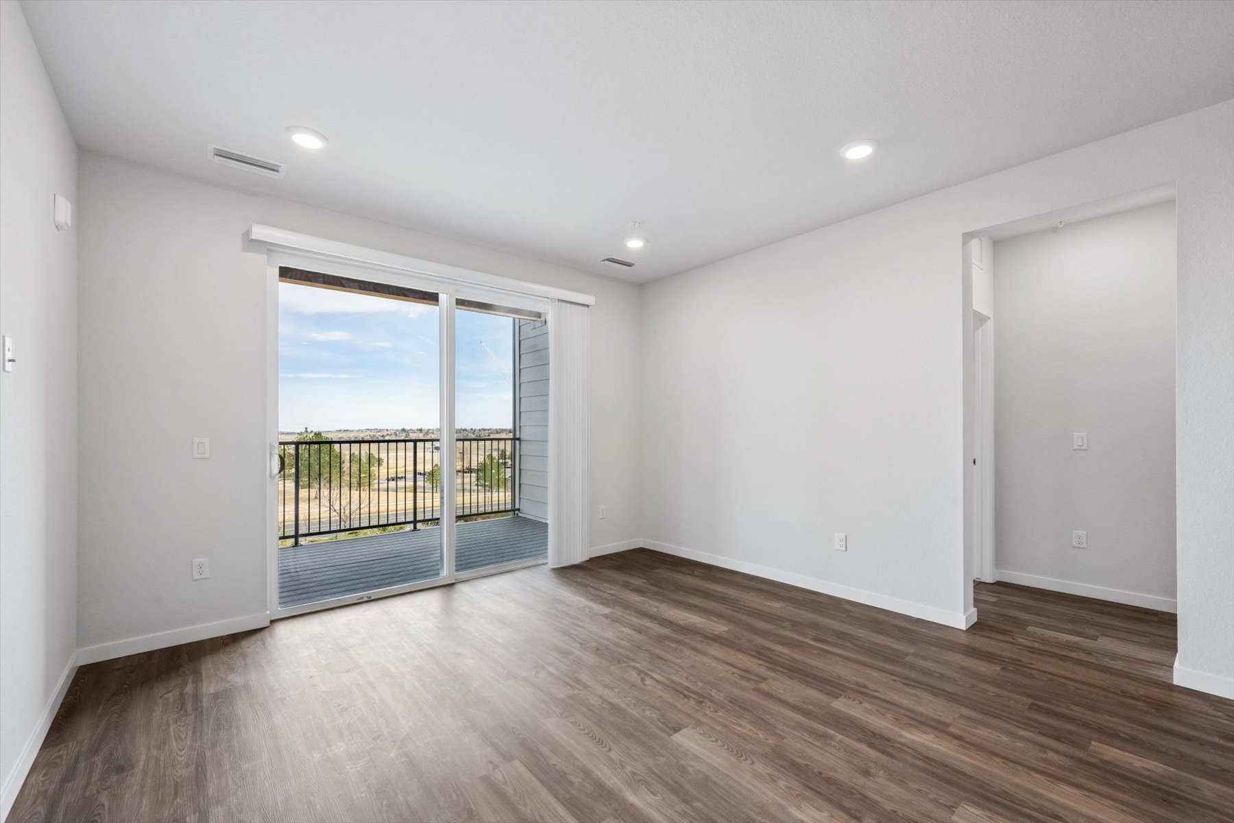 A room with a wood floor and a wood floor with a glass door.