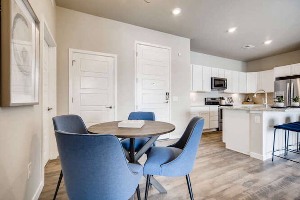 A kitchen with a table and chairs.