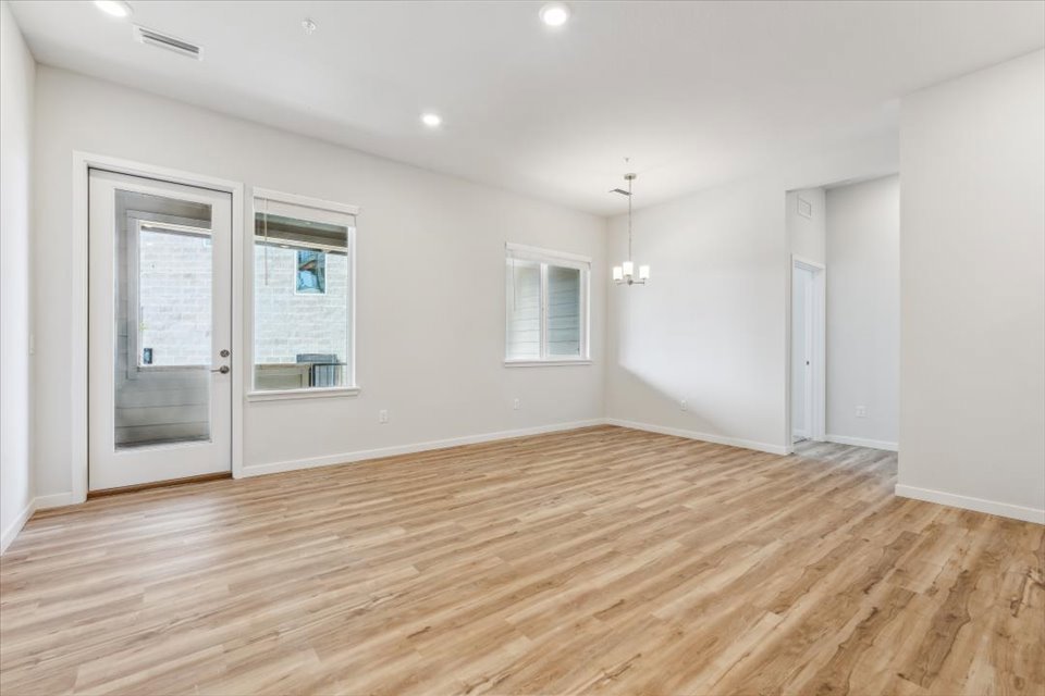 A room with white walls and wood floors.